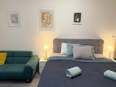 a bedroom with a bed and a couch at RETRO Boho style St Clement with a green oasis in Prague