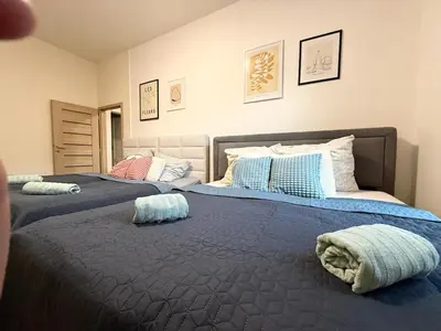 a bedroom with two beds with pillows on them at RETRO Boho style St Clement with a green oasis in Prague