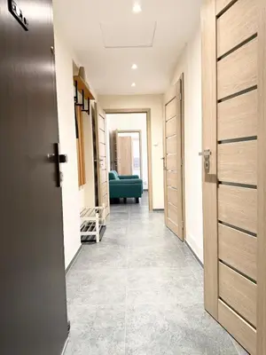 a hallway with doors and a green couch in a room at RETRO Boho style St Clement with a green oasis in Prague