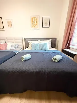 two beds in a bedroom with two pillows on them at RETRO Boho style St Clement with a green oasis in Prague