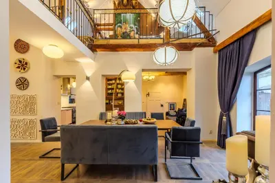 a dining room and living room with a table and chairs at Jevany Four Bedroom Luxury Villa by the Lake with Infrasauna and Grill in Jevany