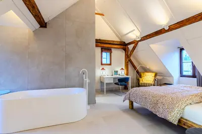 a attic bedroom with a bed and a desk at Jevany Four Bedroom Luxury Villa by the Lake with Infrasauna and Grill in Jevany