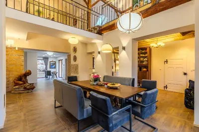 a dining room with a wooden table and blue chairs at Jevany Four Bedroom Luxury Villa by the Lake with Infrasauna and Grill in Jevany