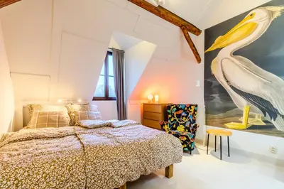 a bedroom with a bed and a large bird painting on the wall at Jevany Four Bedroom Luxury Villa by the Lake with Infrasauna and Grill in Jevany