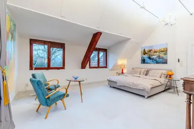 a bedroom with a bed and a table and a chair at Jevany Four Bedroom Luxury Villa by the Lake with Infrasauna and Grill in Jevany
