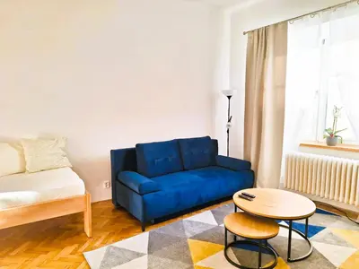 a living room with a blue couch and a table at St. Hubert House in Prague