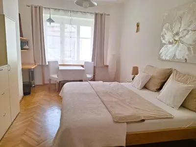 a bedroom with a bed and a table and a window at St. Hubert House in Prague