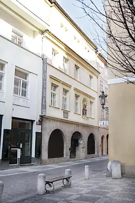 a bench on a street in front of a building at St. Hubert House in Prague