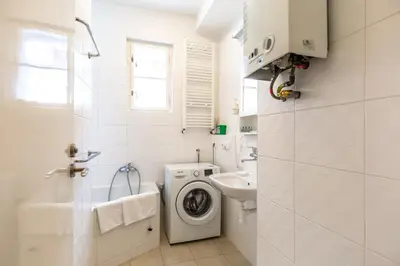 a white bathroom with a washing machine and a sink at St. Hubert House in Prague