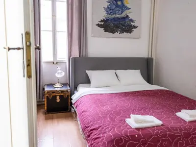 a bedroom with a purple bed with two towels on it at Golden Horse in Prague
