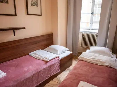 two beds sitting in a room with a window at Golden Horse in Prague