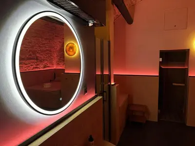 a circular mirror in a room with a bedroom at SPA SPA Petrská in Prague