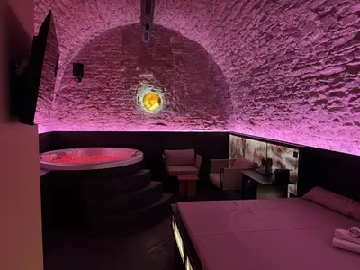 a purple room with a bar with a bath tub at SPA SPA Petrská in Prague