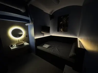 a dark room with a bed and a sink at SPA SPA Petrská hostel in Prague