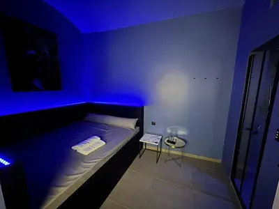 a blue room with a bed and a small table at SPA SPA Petrská hostel in Prague