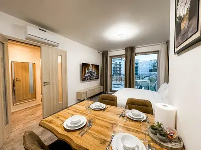 a room with a dining table and a bed at Modern AC Apt | Free Parking | 15 Min Center in Prague