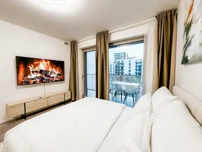 a bedroom with a bed and a tv on a wall at Modern AC Apt | Free Parking | 15 Min Center in Prague
