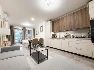 a kitchen and living room with a couch and a table at Modern AC Apt | Free Parking | 15 Min Center in Prague