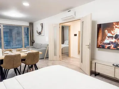 a room with a dining table and a living room at Modern AC Apt | Free Parking | 15 Min Center in Prague