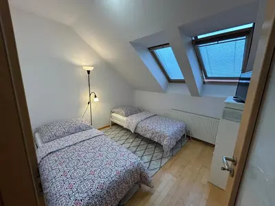 two beds in a room with two windows at Prague For You 22 in Prague
