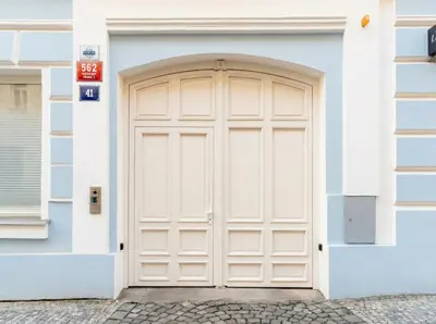 a white door on a blue and white building at Emora Terrace Apartment in Prague