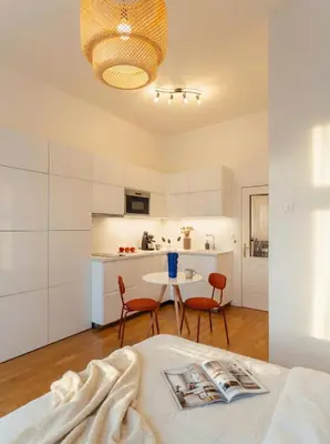 a white kitchen with a table and chairs in a room at Emora Terrace Apartment in Prague