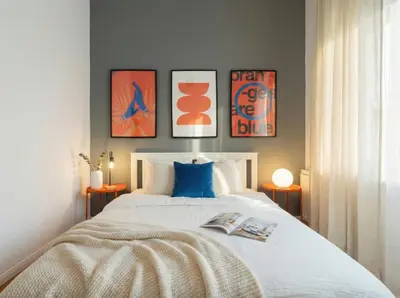 a bedroom with a bed with three paintings on the wall at Emora Terrace Apartment in Prague