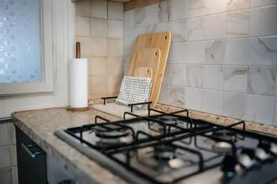 a stove top in a kitchen with a chair at Twin Residence Retro-Cinematic Apartment in City Centre in Prague