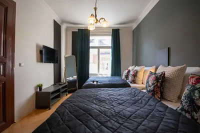 a bedroom with a large bed and a window at Twin Residence Retro-Cinematic Apartment in City Centre in Prague