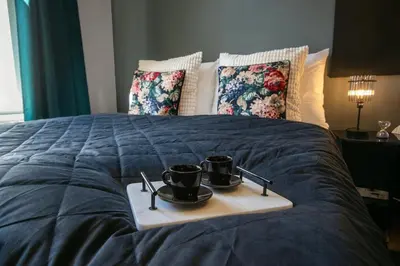 a tray with two cups on top of a bed at Twin Residence Retro-Cinematic Apartment in City Centre in Prague
