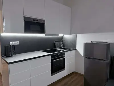 a kitchen with white cabinets and a stove and refrigerator at Parkány Litoměřice in Litoměřice