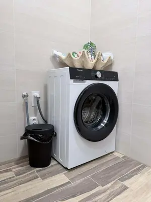 a washing machine in a bathroom with a trash can at Parkány Litoměřice in Litoměřice