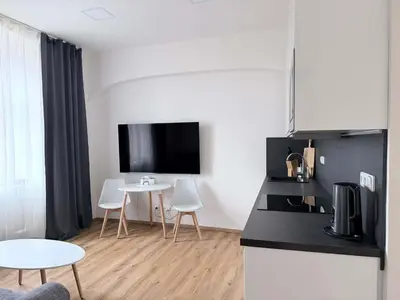 a kitchen with a table and a tv on the wall at Parkány Litoměřice in Litoměřice
