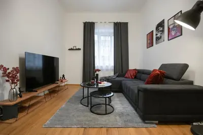 a living room with a couch and a flat screen tv at Downtown Comfort in a Spacious Apartment in Prague