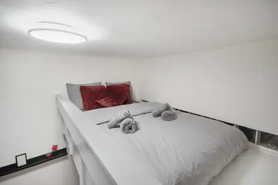 a white bed with two stuffed animals on it at Downtown Comfort in a Spacious Apartment in Prague