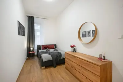 a bedroom with a bed and a mirror on the wall at Downtown Comfort in a Spacious Apartment in Prague