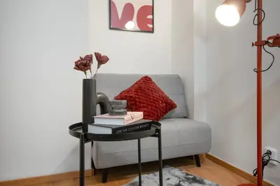 a table with books on it next to a couch at Downtown Comfort in a Spacious Apartment in Prague