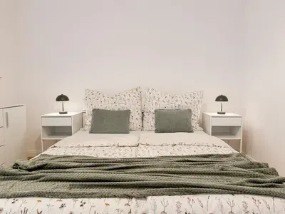 a white bedroom with a large bed with two night stands at REAL Living by REFA - New Town 216 in Prague