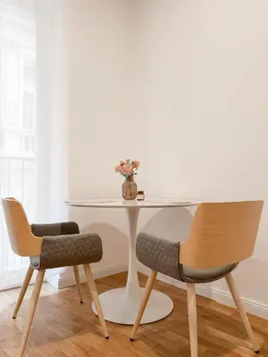 a table with a vase of flowers and two chairs at REAL Living by REFA - New Town 216 in Prague