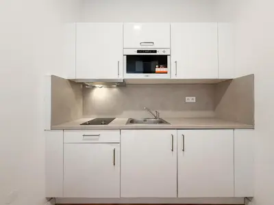 a white kitchen with white cabinets and a sink at REAL Living by REFA - New Town 216 in Prague