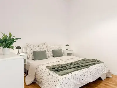 a white bedroom with a bed with a green blanket at REAL Living by REFA - New Town 216 in Prague