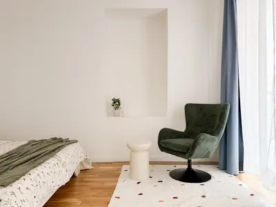 a white bedroom with a bed with a green blanket at REAL Living by REFA - New Town 216 in Prague
