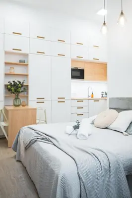 a white bedroom with a bed and a kitchen at Central Studio Apartment with Parking - Near Main Train Station & Wenceslas Square in Prague