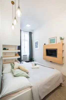 a bedroom with a bed with a tv on the wall at Central Studio Apartment with Parking - Near Main Train Station & Wenceslas Square in Prague