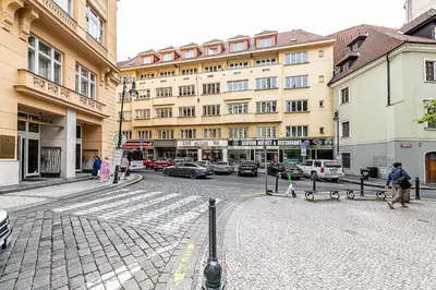 a man walking down a city street with buildings at Central Apartment with breathtaking view in Prague