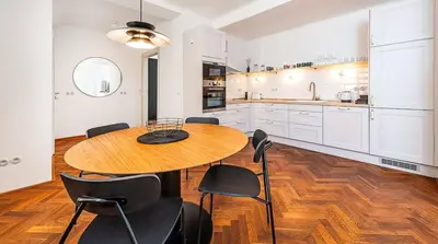 a large kitchen with a wooden table and chairs at Central Apartment with breathtaking view in Prague