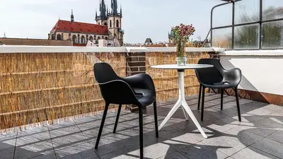 two chairs and a table on a balcony at Central Apartment with breathtaking view in Prague