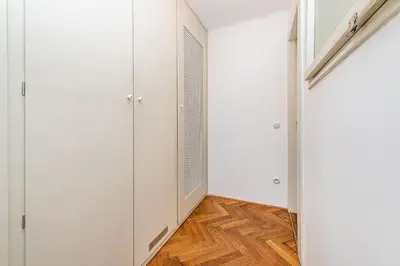 a hallway with white cabinets and a wooden floor at Central Apartment with breathtaking view in Prague