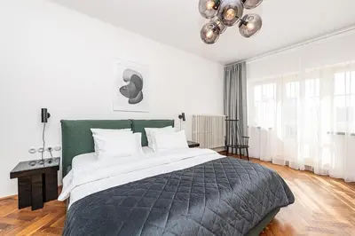 a bedroom with a large bed and a chandelier at Central Apartment with breathtaking view in Prague