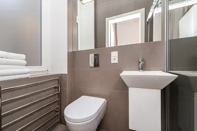 a bathroom with a toilet and a sink and a mirror at Stunning 2 bed in prime central location in Prague